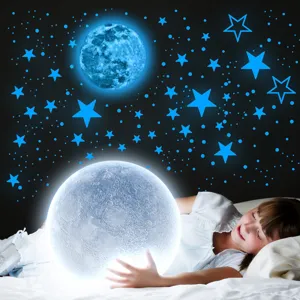 Detail shot of glowing moon and stars wall stickers creating a magical night sky in kids room.