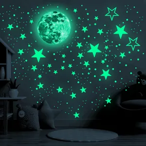 Glow in the dark moon and stars wall stickers in child bedroom nighttime lighting scene detail.