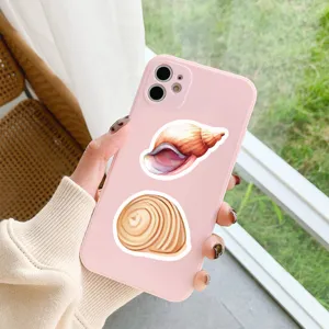 Close-up detail van een roze telefoonhoesje versierd met schattige schelpstickers.