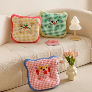 Detailed shot of colorful checkered cat face cushions, cozy home decor and seating accent.
