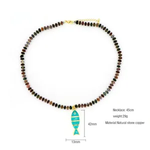 Vue détaillée et gros plan du pendentif poisson en émail coloré avec collier en pierre.