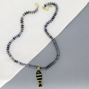 Détail gros plan du collier de perles bleues avec un joli pendentif poisson émaillé.