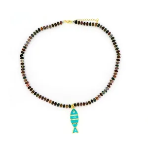 Détail en gros plan du collier de perles en pierre naturelle avec pendentif poisson en émail.