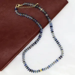 Vue détaillée du collier de perles bleues avec des intercalaires dorés et fermoir homard.