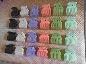 Vista detallada de coloridos clips de rulos para el cabello y pinzas térmicas de plástico.