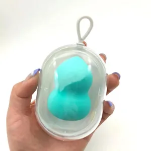 Details of the capsule beauty sponge storage case and soft makeup puff inside a clear container.