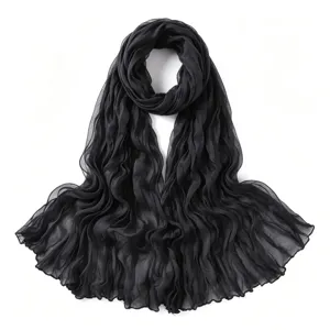 Vue détaillée de l'écharpe noire légère froissée, montrant une texture de tissu respirante.