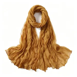 Vue détaillée d'un foulard jaune froissé léger, montrant la texture douce et de fines pliures.