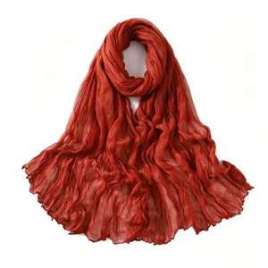 Détail de l'écharpe légère froissée en lin et coton rouge brique respirant et doux.