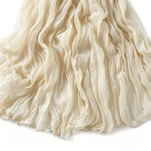 Gros plan détaillé du tissu léger d'écharpe en coton beige avec un beau pli froissé.