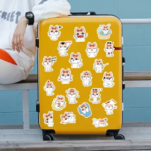 Détail d'autocollants mignons de chats de dessin animé étanches sur une valise jaune.