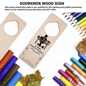 Detailed view of unfinished wooden doorknob sign with DIY painting tools, pencils and leaves.