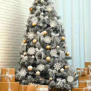 Detailed view of decorated Christmas tree with white snowflake ornaments and gift boxes.