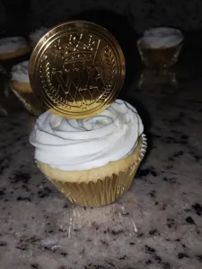 Primer plano detallado del adorno para tarta VIP dorado con un elegante diseño de corona.