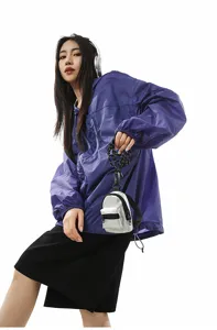 Primer plano de una mini mochila plateada de tendencia con correa de cadena negra.