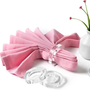 Transparente Acryl Serviettenringe Set mit rosa Stoffserviette für die elegante Tischdekoration.
