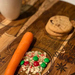Wooden reindeer snack tray detail showing engraved holiday text, cookies and treats.