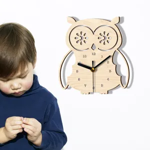 Detailansicht der hölzernen Eulen-Wanduhr mit Zifferblatt und kindlicher Szenen-Dekoration.