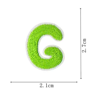 Detailed shot of the cute green embroidered letter G patch, showing size and texture clearly.