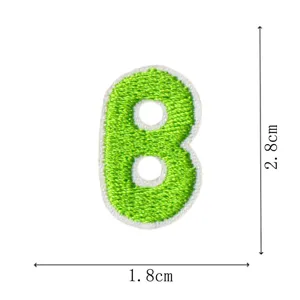 Green letter B embroidered patch detail, miniature DIY clothing accessory and iron-on motif.