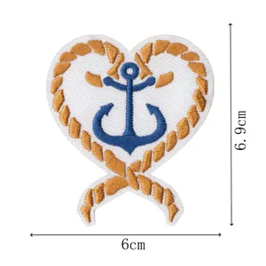 Close-up detail shot of heart-shaped anchor embroidered patch featuring golden rope trim.