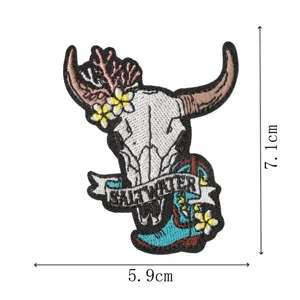Detailed close-up of the western cow skull embroidered patch with floral and cowboy boot motifs.