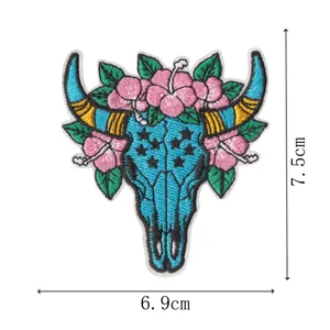 Detail shot of a western cow skull embroidery patch with floral motifs, close-up texture.
