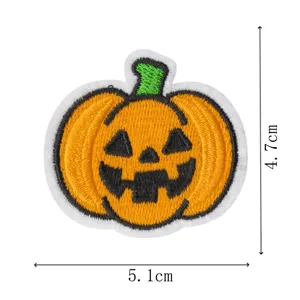 Vista dettagliata dellatoppetta ricamata di zucca di Halloween con cuciture nere e arancioni.