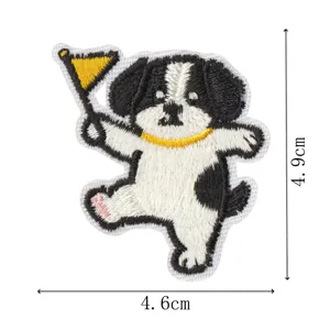 Close-up detail of the cute black and white puppy embroidered patch with yellow flag and collar.