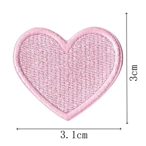 Nahaufnahme Detailansicht des rosa herzförmigen Stickaufnähers mit feiner Stichstruktur.