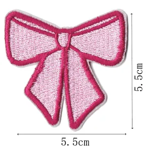 Close-up detail shot of a pink embroidered bow patch, showing fine stitching and clear size.