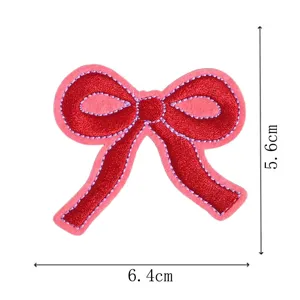 Primer plano del parche bordado de lazo rojo con costuras violetas para decoracion de ropa.