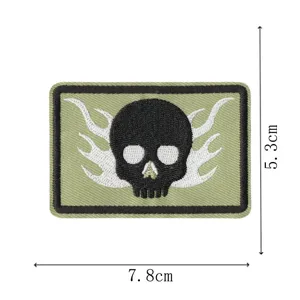Gedetailleerd overzicht van de geborduurde tactische schedelpatch met witte vlammen en khaki.