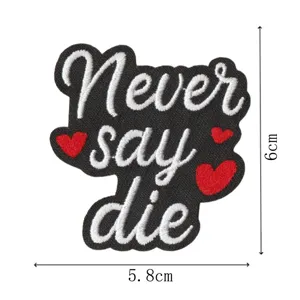 Nahaufnahme des gestickten Aufnähers mit Never say die Text und roten Herzmotiven im Detail.