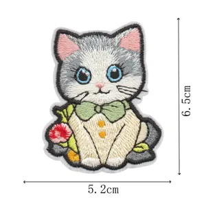 Gros plan détaillé du joli patch brodé en forme de chat avec un nœud et de belles finitions.