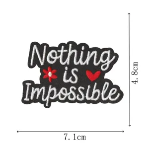Bestickter Aufnäher mit Nothing is Impossible Text, roter Blume und Herz, Detailaufnahme.
