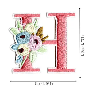 Detailed view of pink letter H embroidered patch with cute floral design for DIY crafts.