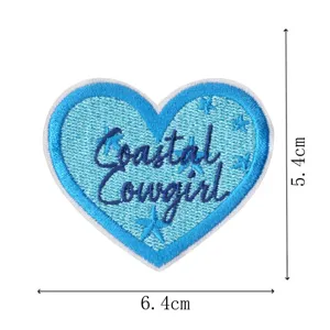 Blue heart embroidered patch detail, featuring coastal cowgirl lettering and cute star design.