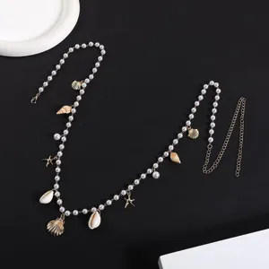 Vue détaillée de la chaîne de taille perlée bohème avec pendentifs coquillage et étoile.