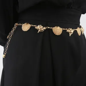Close-up view of a gold metal waist chain featuring delicate seashell and conch charms.