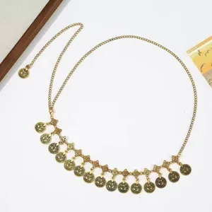Detail view of ethnic vintage gold coin waist chain, delicate tassel metal belt accessory.