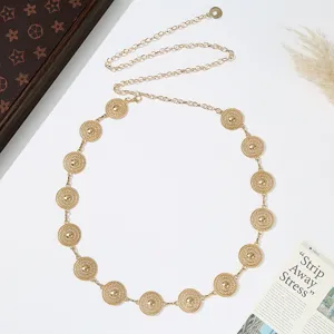 Exquisite gold-tone metal medallion waist chain detail, elegant body jewelry accessory.