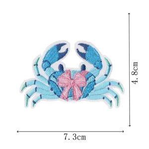 Blue crab embroidered patch detail showing precise size dimensions and delicate pink bow design.