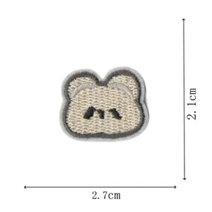 Vue détaillée d'un joli patch brodé en forme d'animal ours accessoire de vêtement.