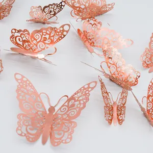 Detalle de decoracion de pared mariposa hueca metalica 3D en elegante color oro rosa.