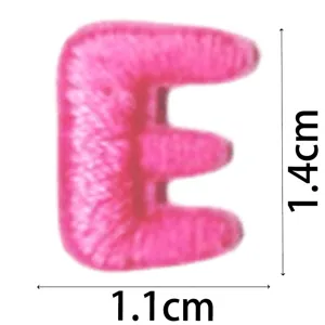 Pink embroidered letter E patch detail closeup, mini DIY clothing accessory decoration.