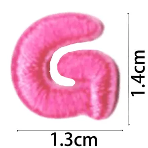 Close-up of pink letter G embroidery patch detail, cute DIY clothing accessory iron-on