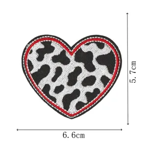 Heart shaped cow print embroidered patch with iron on backing for clothing decoration.
