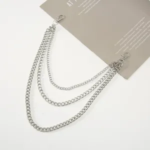 Close-up of multi-layer silver punk chain detail, metallic pants chain texture.