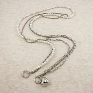 Detail shot of pearl and metal layered chain strap with heart pendant for phone or bag.